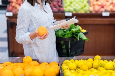 Woman shopping for food with high levels of vitamin C